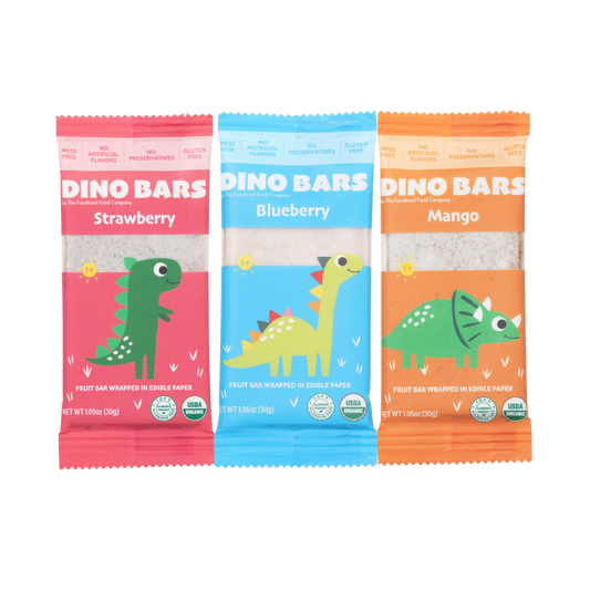 Three Dino Bars fruit bars in individual colorful wrappers, shown side by side on a plain white background. The wrappers are pink for Strawberry, light blue for Blueberry, and orange for Mango, each featuring a cartoon dinosaur illustration and the brand name DINO BARS.